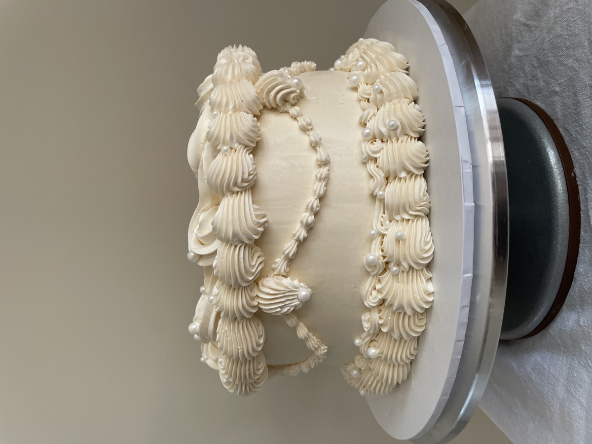 Elegant white piped cake with pearl details