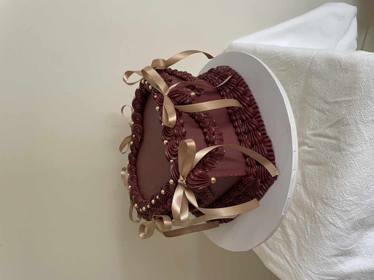 Heart-shaped chocolate cake with gold ribbon bows